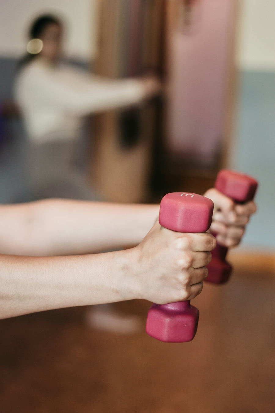 Hand met twee lichte dumbbells voor krachttraining