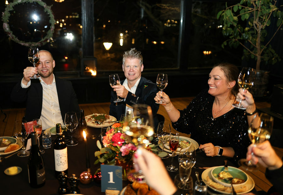 Vrienden klinken samen aan tafel tijdens een gezellig etentje op restaurant